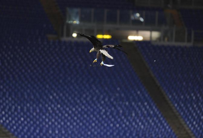 L'aquila Olimpia spicca il volo prima della partita contro l'Udinese, con la deserta Curva Nord sullo sfondo. Ansa